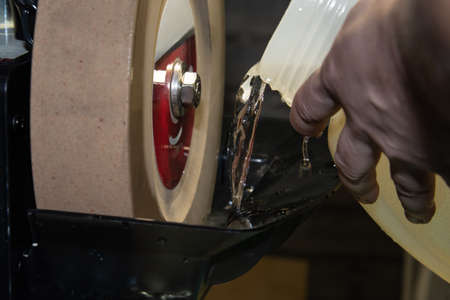 The process of pouring water into the tank for grinding stoneの写真素材
