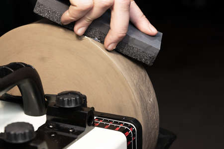 Leveling the grinding stone with a blade for sharpening knives