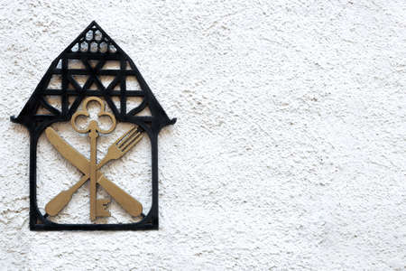 A sign on the wall with the image of the house key knife and fork.の写真素材