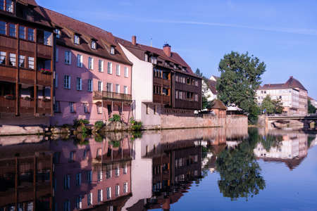 A number of houses stand on the banks of the Pegnitz River in Nuremberg Germanyの写真素材