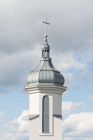 View of the dome and bell tower of a modern Catholic church against a blue sky with clouds. Concept architecture, easter, religionの写真素材