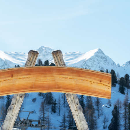 Blank billboard for outdoor advertising from logs and a wooden board on a ski slope against the backdrop of the mountains. The concept of advertising, landscape, sportの写真素材