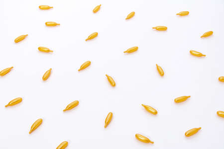Top view on golden capsules with collagen on a white background. The concept of beauty, facial skin care, cosmetology, medicineの写真素材