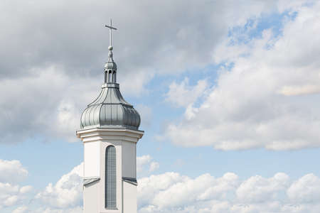 View of the dome and bell tower of a modern Catholic church against a blue sky with clouds. Concept architecture, easter, religionの写真素材