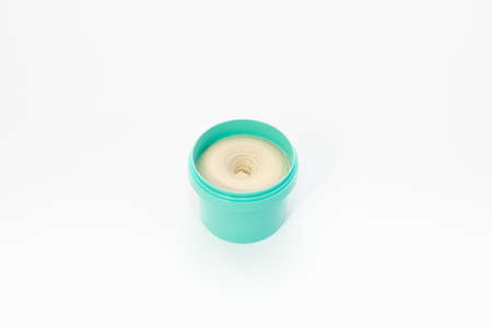 Top view on a bright jar of turquoise color with cosmetic cream on a white background. The concept of beauty, medicine, facial and body skin care, hair careの写真素材