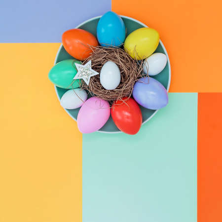 Bright background with a non-symmetrical geometric pattern in a fashionable color scheme with a composition of their Easter eggs and stars that lie on a plate. Concept background, holiday, easterの写真素材