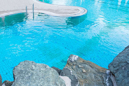 Top view of a blue water pool surrounded by stones. The concept of summer, relaxation, spa, aqua park, sports, architectureの写真素材