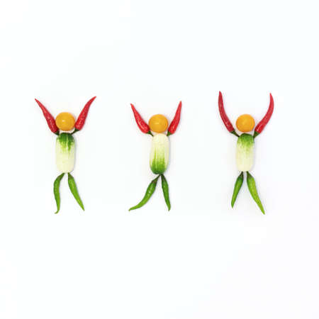 Top view of a flat lay over abstract background of joyful people who are laid out of vegetables on a white background with copy space. Concept networking, equality, design, healthy eating.の写真素材