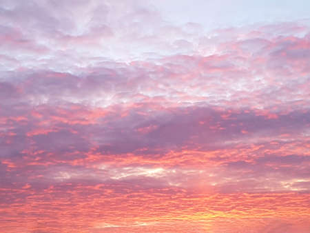 A view of the sky with thick clouds at sunset in bright orange and purple tones. Concept landscape, nature, backgroundの写真素材