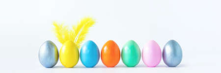 Top view of an easter composition of painted eggs in bright juicy colors on a white background with feather rabbit ears. Vacation concept, flat design, minimalismの写真素材