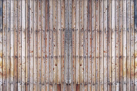 A solid wall of aged brown wooden planks with clogged nails located vertically. Concept for texture, background, interiorの写真素材