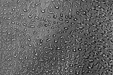 View on a black-white background with the texture of flowing drops of water on glass through a transparent fabric. Concept background, textureの写真素材