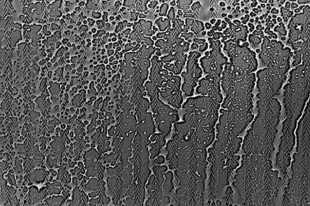 View on a black-white background with the texture of flowing drops of water on glass through a transparent fabric. Concept background, textureの写真素材