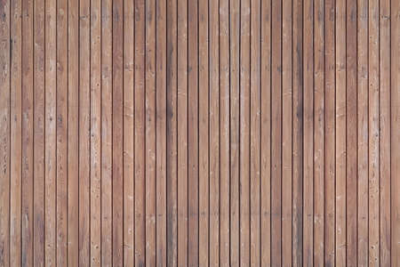 A solid wall of aged brown wooden planks with clogged nails located vertically. Concept for texture, background, interiorの写真素材