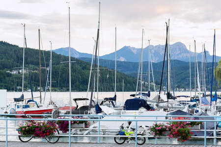 View of the yachts moored near the pier on the lake against the backdrop of the mountains in the evening at sunset. Concept landscape, backgroundの写真素材