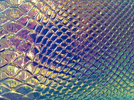 A shiny neon colored surface with many small cells of different sizes. Concept texture, backgroundの写真素材