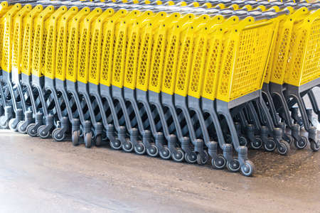 View of a row of yellow shopping carts stacked one into another. Concept for business, trade, crisis