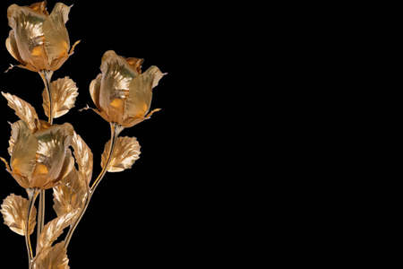 Contemporary collage. Gold colored metal roses on a black backgroundの写真素材