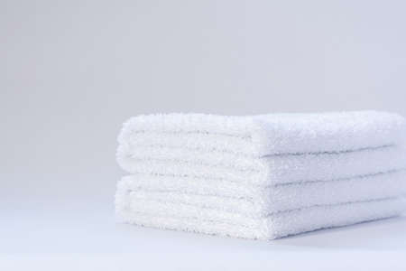View of a stack of white folded terry towels on a light backgroundの写真素材