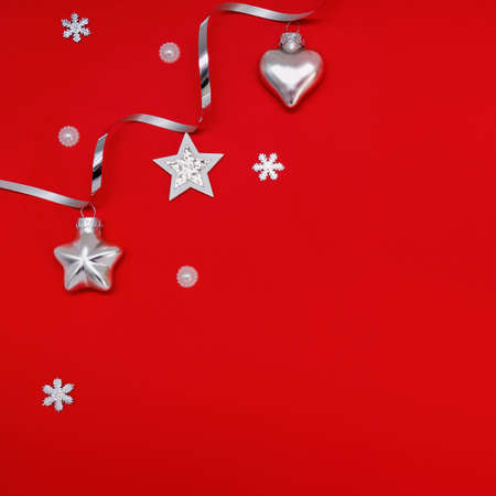 Flat composition of Christmas decorations in silver on a red background.の写真素材