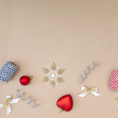 Flat composition of Christmas decorations in red, white, gold and silver on a beige background.の写真素材