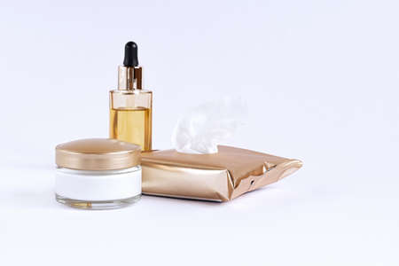 Glass jar with cream, cleaning wipes and glass bottle with a pipette with face serum on a white background.の写真素材