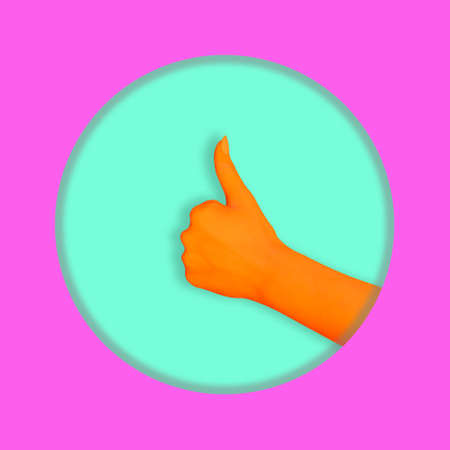 Contemporary collage. An orange human hand is depicted with a like gesture on a turquoise background in a round pink frameの写真素材