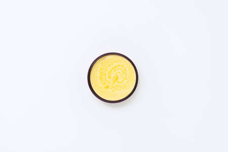 Black jar with yellow cream with sea buckthorn oil on a white background.の写真素材