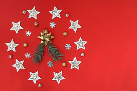 Flat composition of Christmas decorations in white and gold and fir branches on a red backgroundの写真素材