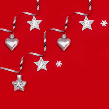 Flat composition of Christmas decorations in silver on a red backgroundの写真素材