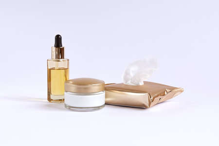 Glass jar with cream, cleaning wipes and glass bottle with a pipette with face serum on a white backgroundの写真素材