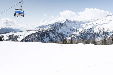 View of the snow-capped mountains and the cable car with blue chair cabins. Concept for sports, landscape, technologyの写真素材