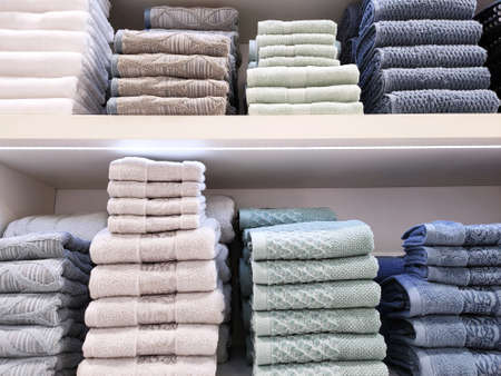 Terry towels of various colors are folded neatly on the shelves. Concept for lifestyle, retail, comfortの写真素材