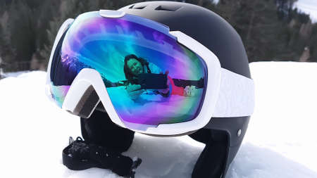 View of a ski helmet with sunglasses reflecting a woman. Landscape, industry, sports conceptの写真素材