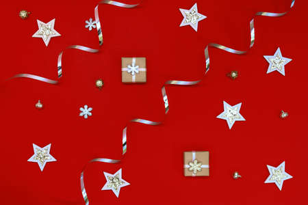 Flat composition of Christmas decorations in silver and holiday boxes on a red backgroundの写真素材