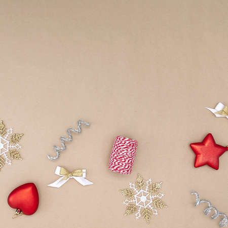 Flat composition of Christmas decorations in red, white, gold and silver on a beige backgroundの写真素材