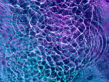 Water texture with circular streaks on the surface, bubbles and sun glare. Concept background, texture, abstraction.の写真素材