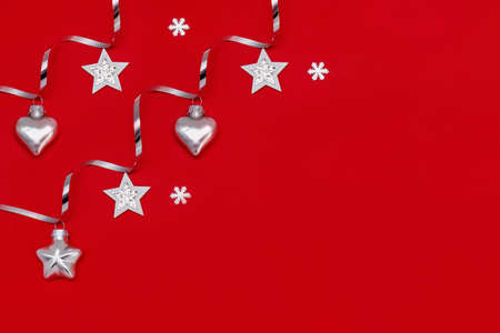 Flat composition of Christmas decorations in silver on a red background.の写真素材