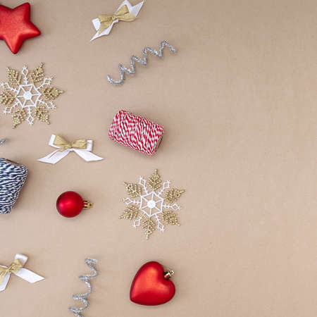 Flat composition of Christmas decorations in red, white, gold and silver on a beige background.の写真素材