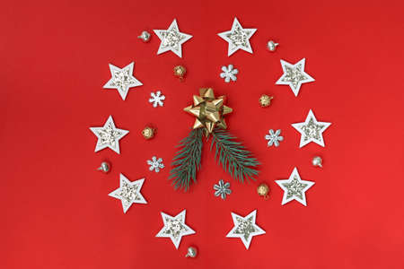 Flat composition of Christmas decorations in white and gold and fir branches on a red background.の写真素材