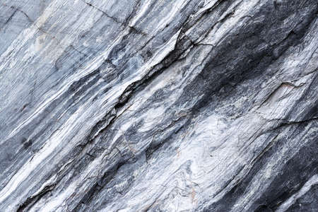 The texture of a marble rock with cracks and a pattern in the form of straight and wavy lines located diagonally. Concept background, texture, nature.の写真素材