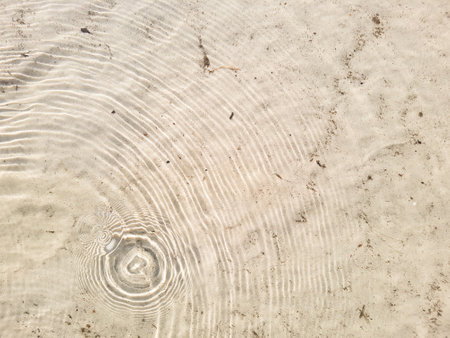 Natural background of water and sand with round streaks on the surfaceの写真素材