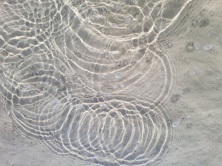Natural background of water and sand with round streaks on the surfaceの写真素材