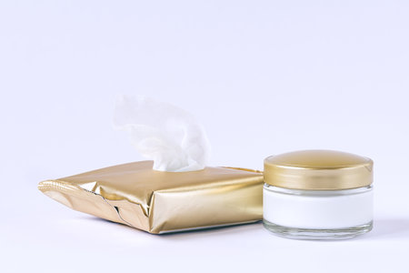 Glass jar with cream and facial cleansing wipes on a white backgroundの写真素材