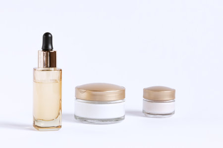 A set for the care of the skin around the eyes and skin consisting of glass jars of cream and a bottle with a serum pipette ..の写真素材