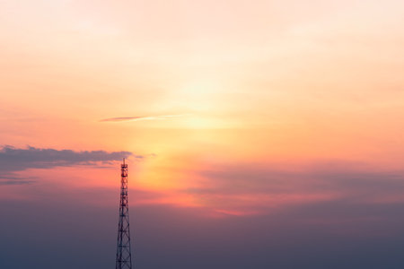 A view of the signal tower at sunset in vibrant orange pinks and violet colors.の写真素材
