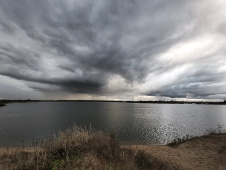 A dramatic view of the lake above which a dark cloud has formed.の写真素材