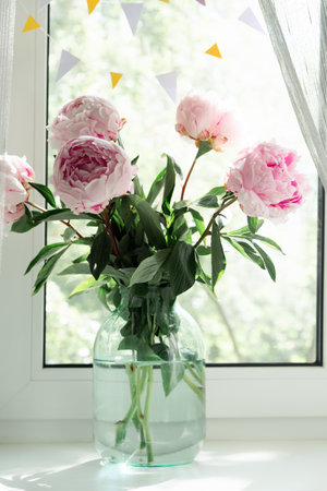 A view of a bouquet of pink peonies standing in a vase on the window. Concept background, flowers, holidayの写真素材