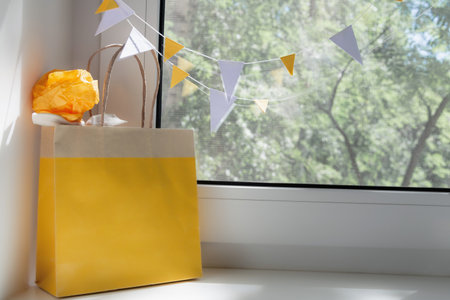 View of the yellow bag with a gift on the window. Holiday concept, backgroundの写真素材
