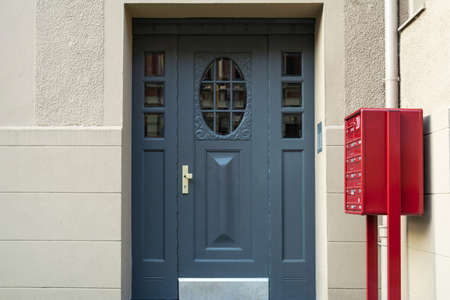 A view of a blue front door and a red mailbox in an apartment building.の写真素材